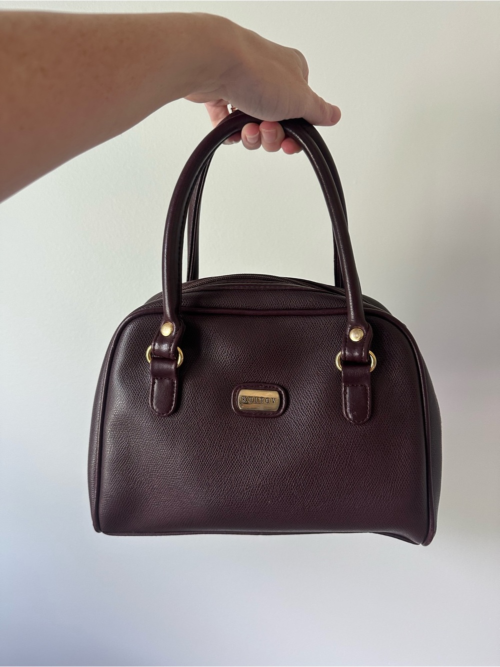 Vintage-inspired burgundy/oxblood structured handbag with gold accents
